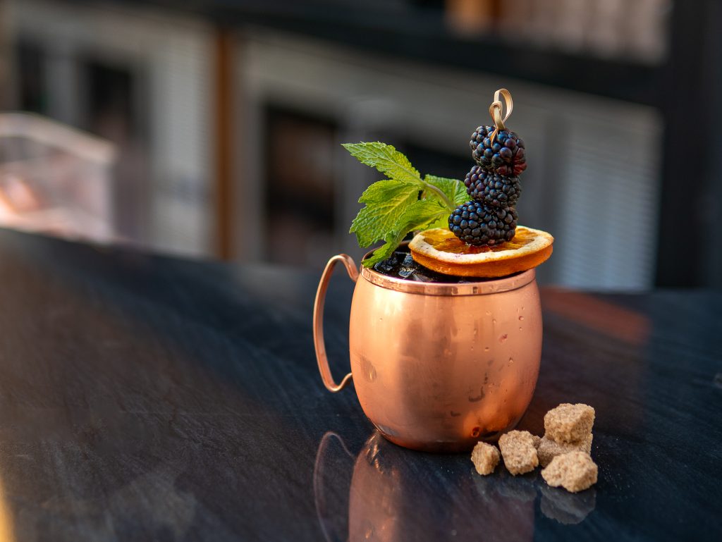 cocktail on top of a bar in a copper mug