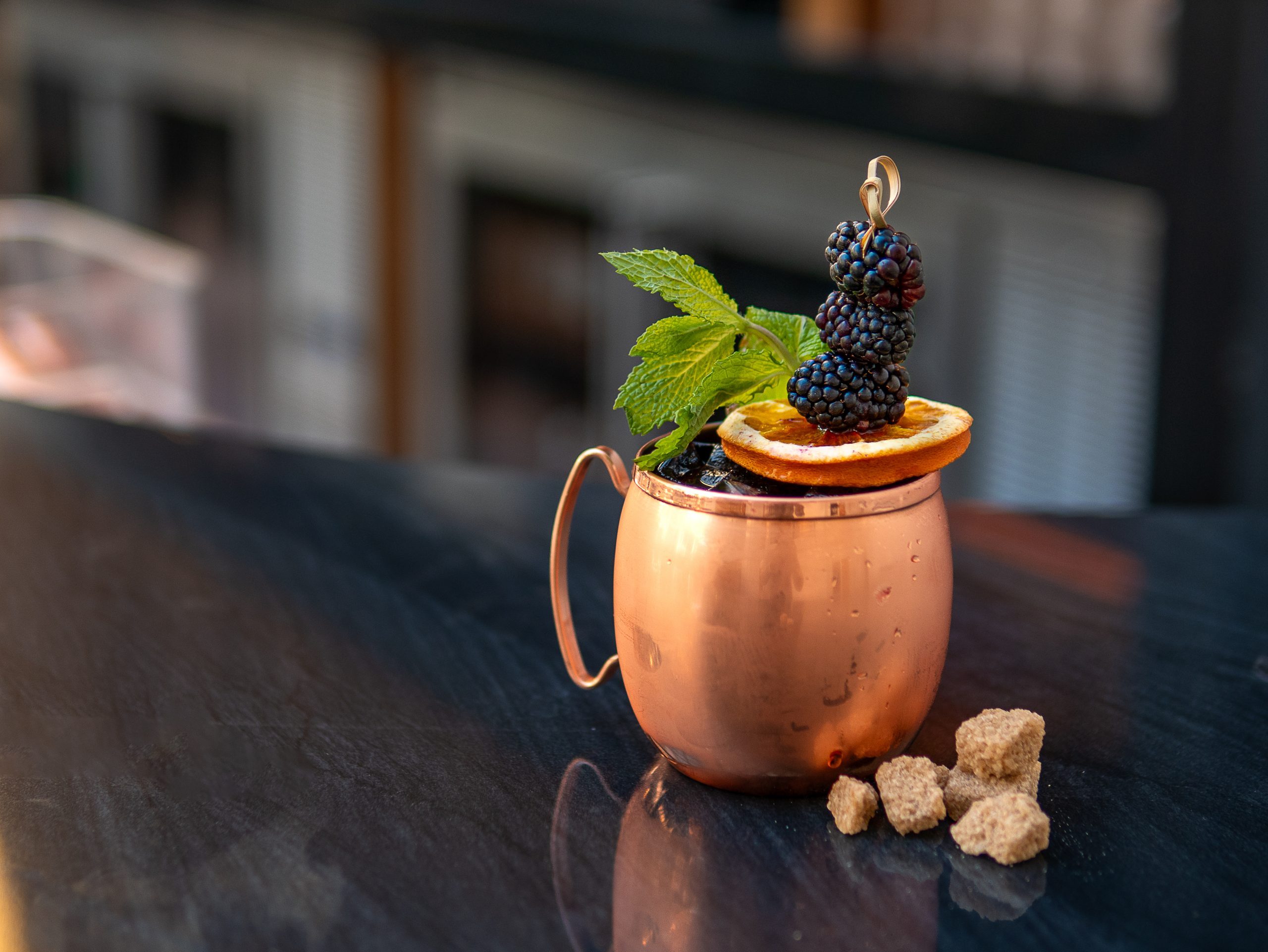cocktail on top of a bar in a copper mug